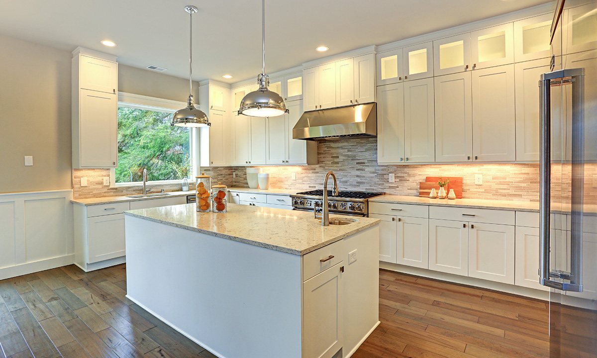 Remodeled white kitchen with island by Ico Construction